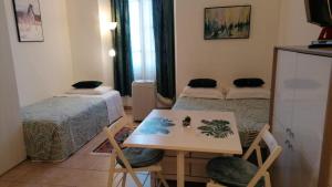a small room with two beds and a table at Lovely view in Nice