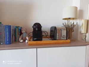 a shelf with a coffee maker and a toaster and books at Lovely view in Nice