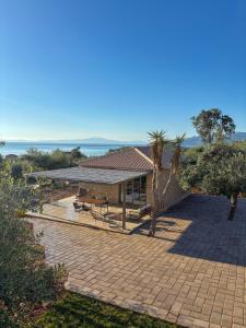 ein Haus mit einer Terrasse und einem Tisch davor in der Unterkunft Riverstone Villas with private pools in Lévktron
