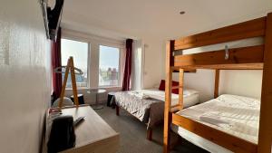 a bedroom with a bunk bed and a desk and a bed at Reef Lodge in Newquay