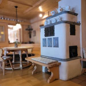 Una estufa en una habitación con dos mesas y bancos. en Hotel Gästehaus Gross, en Aschheim