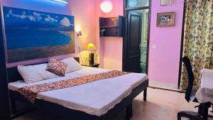 Dr Balis Bliss Homestay Sarvodya Enclave في Jāmb: غرفة نوم بها سرير ولوحة على الحائط +3 صور