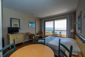 a hotel room with a bed and a balcony at Résidence Vacances Bleues Le Grand Large in Biarritz