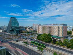 波兹南波兹南中心美居酒店的一座有建筑的城市和一条有汽车的街道