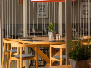 a dining room with a wooden table and chairs at Novotel Kraków City West in Kraków