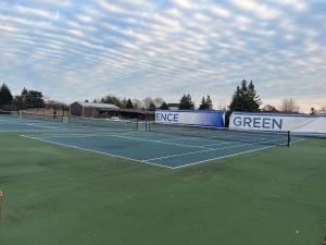 a tennis court with two tennis nets on it at The Porchlight retreat in Farmington Hills