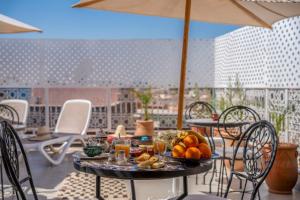 a table with fruit on it on a patio at Riad HAFSSA & Spa in Marrakesh