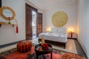 a bedroom with a bed and a table and a mirror at Riad HAFSSA & Spa in Marrakech