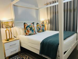 ein Schlafzimmer mit einem Himmelbett und Kissen in der Unterkunft Sarona LoLa E206 in Gaborone + 48 Fotos