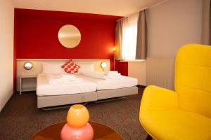 una stanza d'albergo con un letto e una sedia di Hessenland Hotel Kassel Innenstadt by Stay Awesome a Kassel