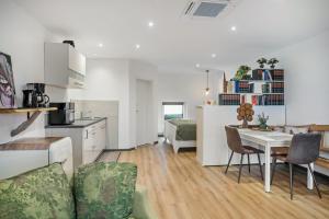 eine Küche und ein Wohnzimmer mit Tisch und Stühlen in der Unterkunft Ferienwohnung Eifelzauber in Willwerscheid + 17 Fotos