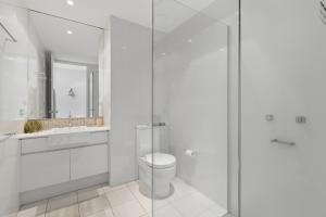 Sea Salt - Peppers Balé 1BR Apartment by uHoliday في كينغسكليف: حمام ابيض مع مرحاض ودش زجاجي