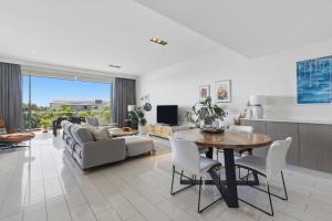 Sea Salt - Peppers Balé 1BR Apartment by uHoliday في كينغسكليف: غرفة معيشة بها طاولة وأريكة