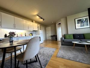 a kitchen and living room with a table and a couch at Aurora Borealis Apartment - Sleeps 3 - Parking in Hjorten +3 photos