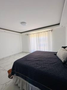 a bedroom with a large bed in a white room at Private Room behind Out of Africa in Otjiwarongo