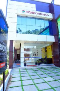 una vista frontale di un edificio con una farmacia di Homey Residency vythiri a Padinjarathara