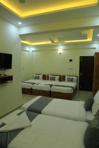 Camera con 4 letti e TV di Homey Residency vythiri a Padinjarathara