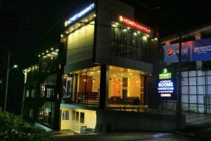 a building with lights on the side of it at night at Homey Residency vythiri in Padinjarathara