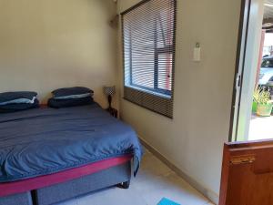 een slaapkamer met een bed en een raam bij Mvuli haven in Pretoria