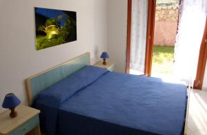 una camera da letto con un letto blu e una finestra di Miriacheddu a San Teodoro