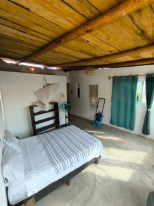 Habitacion vista al mar, Villa fiorito Zipolite. في زيبوليت: غرفة نوم بها سرير وسقف خشبي