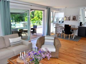 Una sala de estar con un sofá y sillas y una mesa. en The House of Port Haf 2, en Niendorf