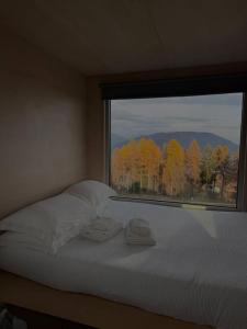 a bed in a room with a large window at Rallentare immersi nel verde di Cima Lan 