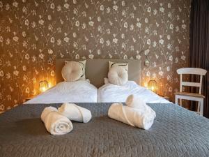 Un dormitorio con dos camas con toallas encima. en Lovely villa on the edge of the forest, en Westermient