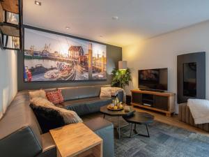 Una sala de estar con un sofá y un televisor. en Lovely villa on the edge of the forest, en Westermient