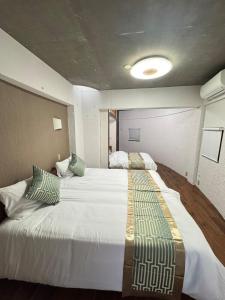 a bedroom with a large white bed in a room at MARU KIX House in Izumi-Sano