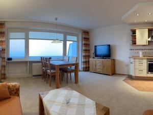 Una sala de estar con una mesa de comedor y una cocina. en Bünemann Gäthke Comfortable holiday residence, en Horumersiel