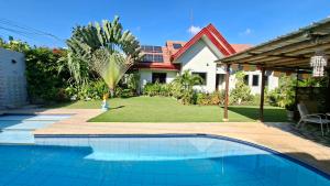 a swimming pool in front of a house at Villa Shangri-La in Dumaguete