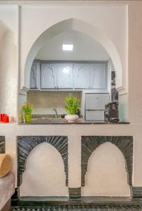a kitchen with white cabinets and a counter top at Cocon Chic et Élégant Quartier Hivernage in Marrakech +6 photos