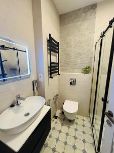 un baño con lavabo e inodoro en Stylish, Brand-New 2BR Apt with Panoramic View, en Itʼkhvisi