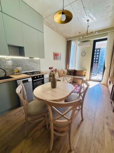Una cocina y un comedor con mesa y sillas. en Stylish, Brand-New 2BR Apt with Panoramic View, en Itʼkhvisi