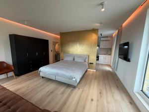 una camera da letto con un letto e una televisione di Beach House in Ardennes a Chaudfontaine