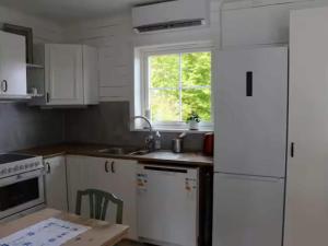 Una cocina con gabinetes blancos y un fregadero y una ventana. en 4 person holiday home in LUR, en Lur