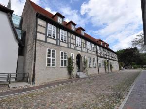a large brick building with white windows on a street at Wellenreiter Comfortable holiday residence in Ribnitz-Damgarten