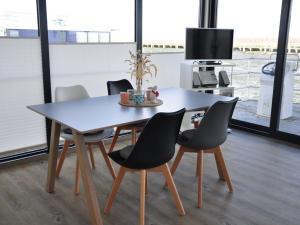 a dining room table with chairs and a tv at Wellenreiter Comfortable holiday residence in Ribnitz-Damgarten