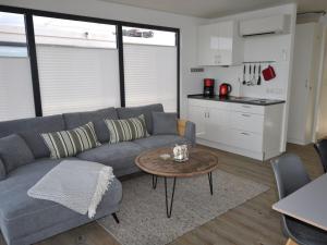 a living room with a couch and a table and a kitchen at Wellenreiter Comfortable holiday residence in Ribnitz-Damgarten