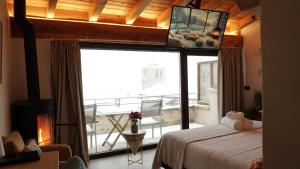 Una habitación con una cama y un balcón con vistas. en Hotel Boutique Poeta Jorge Manrique, en Segura de la Sierra