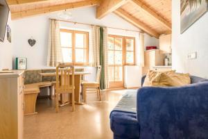 a living room with a blue couch and a table at Voglbach, Bauernhof in Rauris