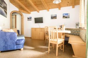 a living room with a table and a blue couch at Voglbach, Bauernhof in Rauris