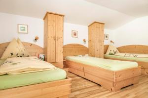 two beds in a room with wooden furniture at Voglbach, Bauernhof in Rauris