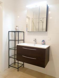 a bathroom with a sink and a mirror at BohoNest Mariatrost - Erdgeschoss, Basilika kostenloser Parkplatz in Größing +6 photos