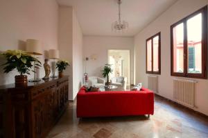 a living room with a red couch and a table at Hotel Canada in Florence +4 photos