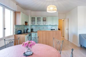 a kitchen with a table with a vase of flowers on it at Spacieux T3 cosy au cœur d’Hossegor in Soorts-Hossegor