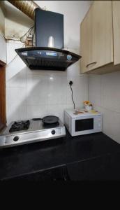 a kitchen with a stove and a microwave at Sagar Niwas in New Delhi