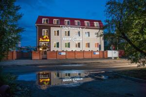 un reflejo de un edificio en un charco en Hotel Khalif, en Tomsk