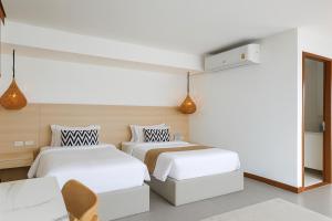 zwei Betten in einem Zimmer mit weißen Wänden in der Unterkunft Villa Nevaeh - Ocean Front Private Villa Kamala Beach in Phuket + 21 Fotos